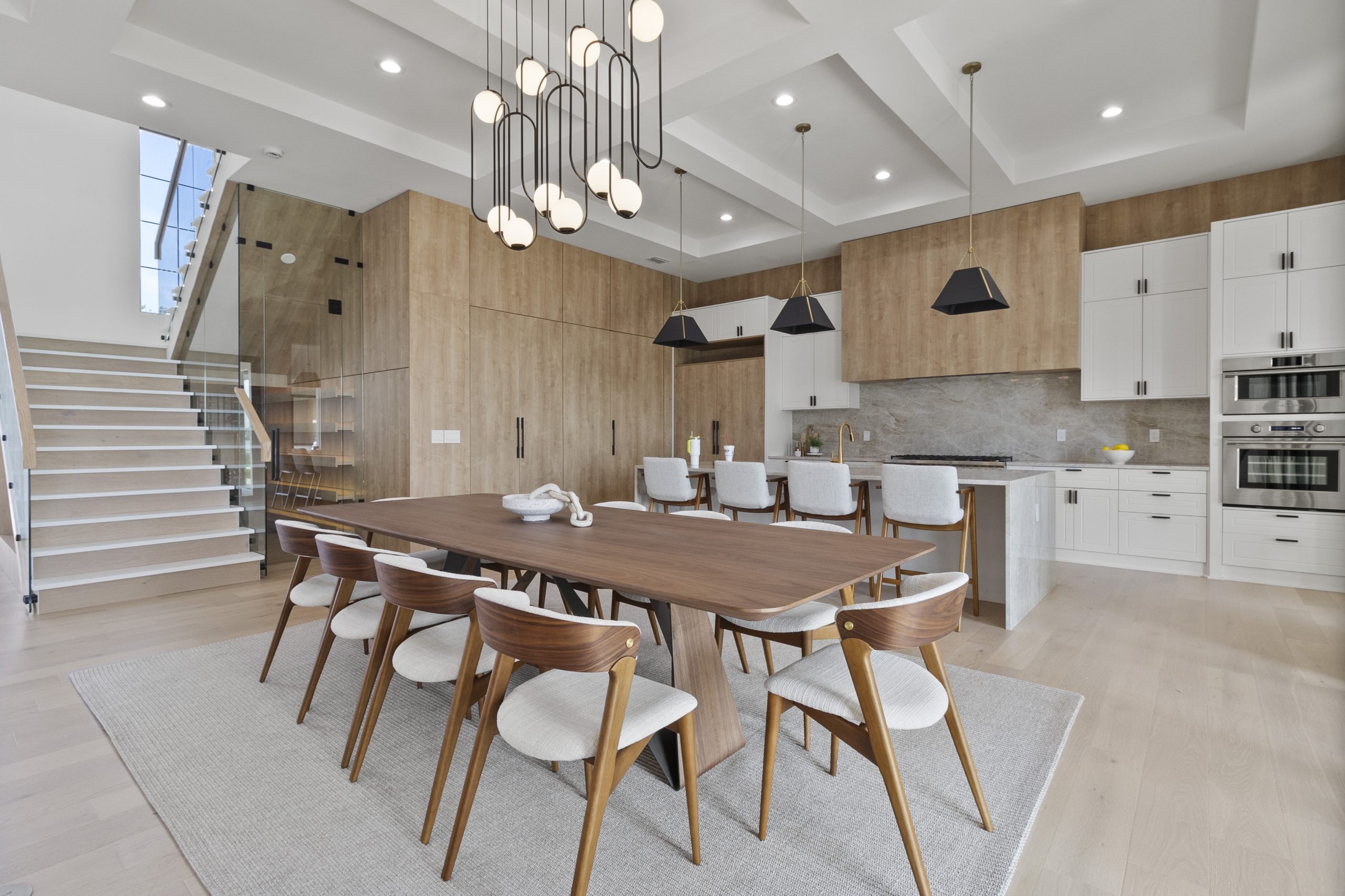 Cozinha americana em casa nos estados unidos, de alto padrão, integrada com varanda, living e área gourmet. Cozinha com tons amadeirados e cinzas. Puxadores pretos.