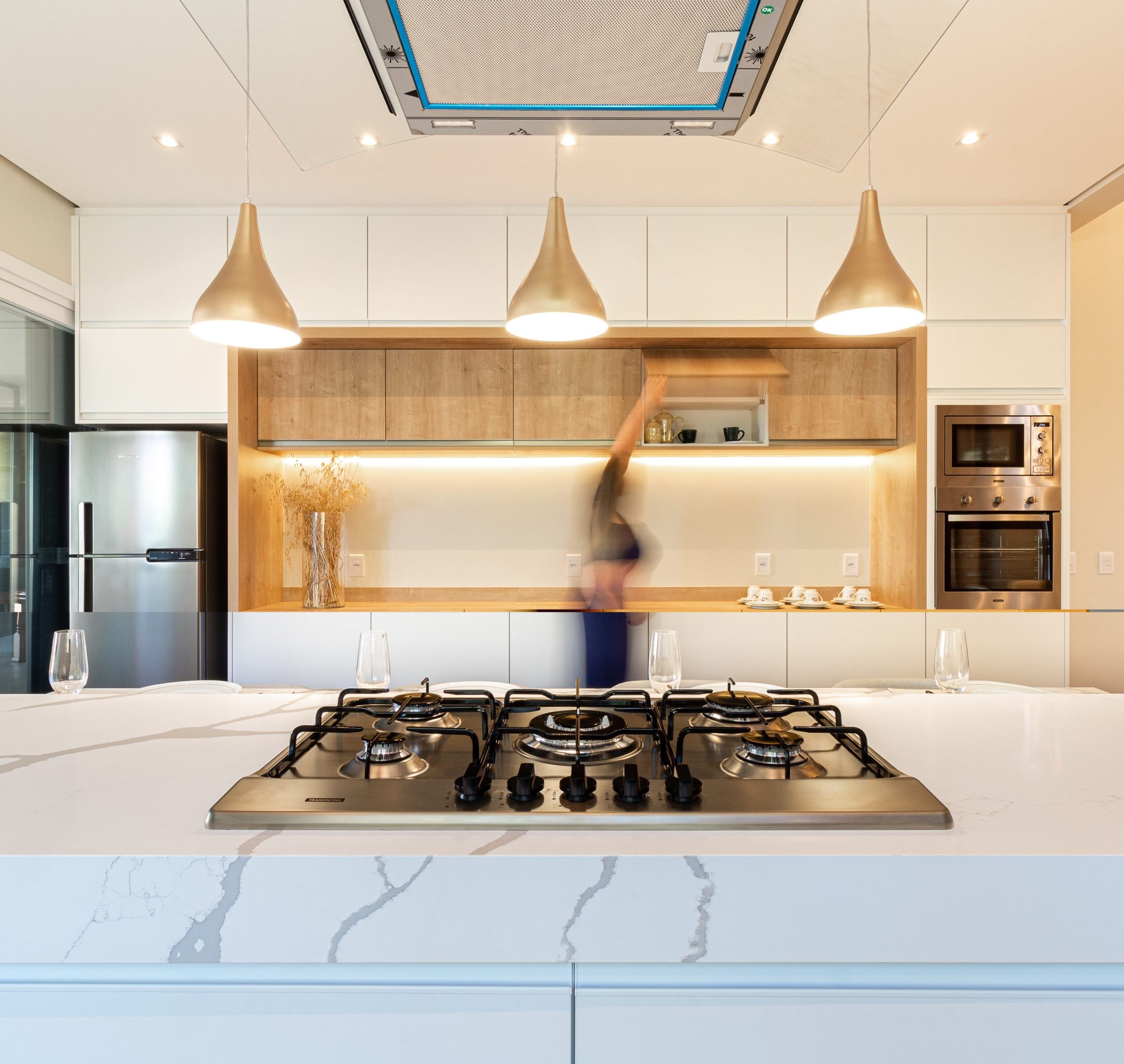 ergonomia em casa - cozinha grande com móveis planejados em tons claros com mármore calacata - cor branca e madeira 