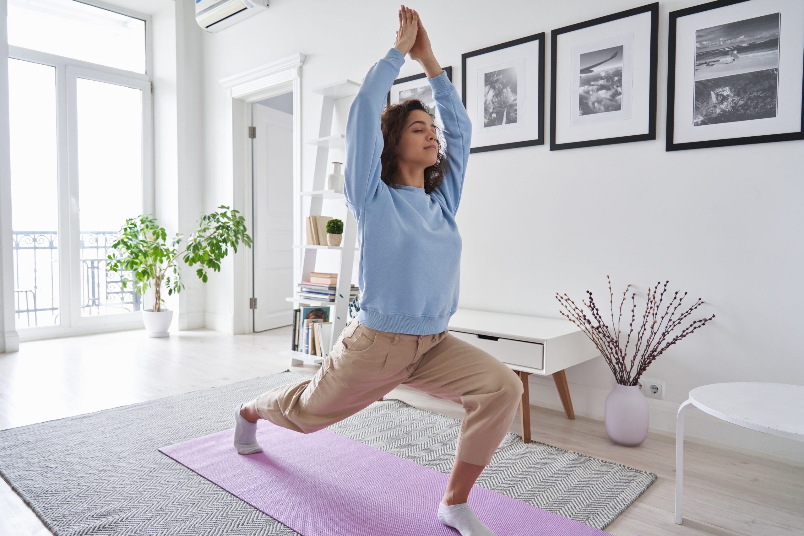 Slow living - mulher praticamente yoga em casa, cuidando da saúde - fitness