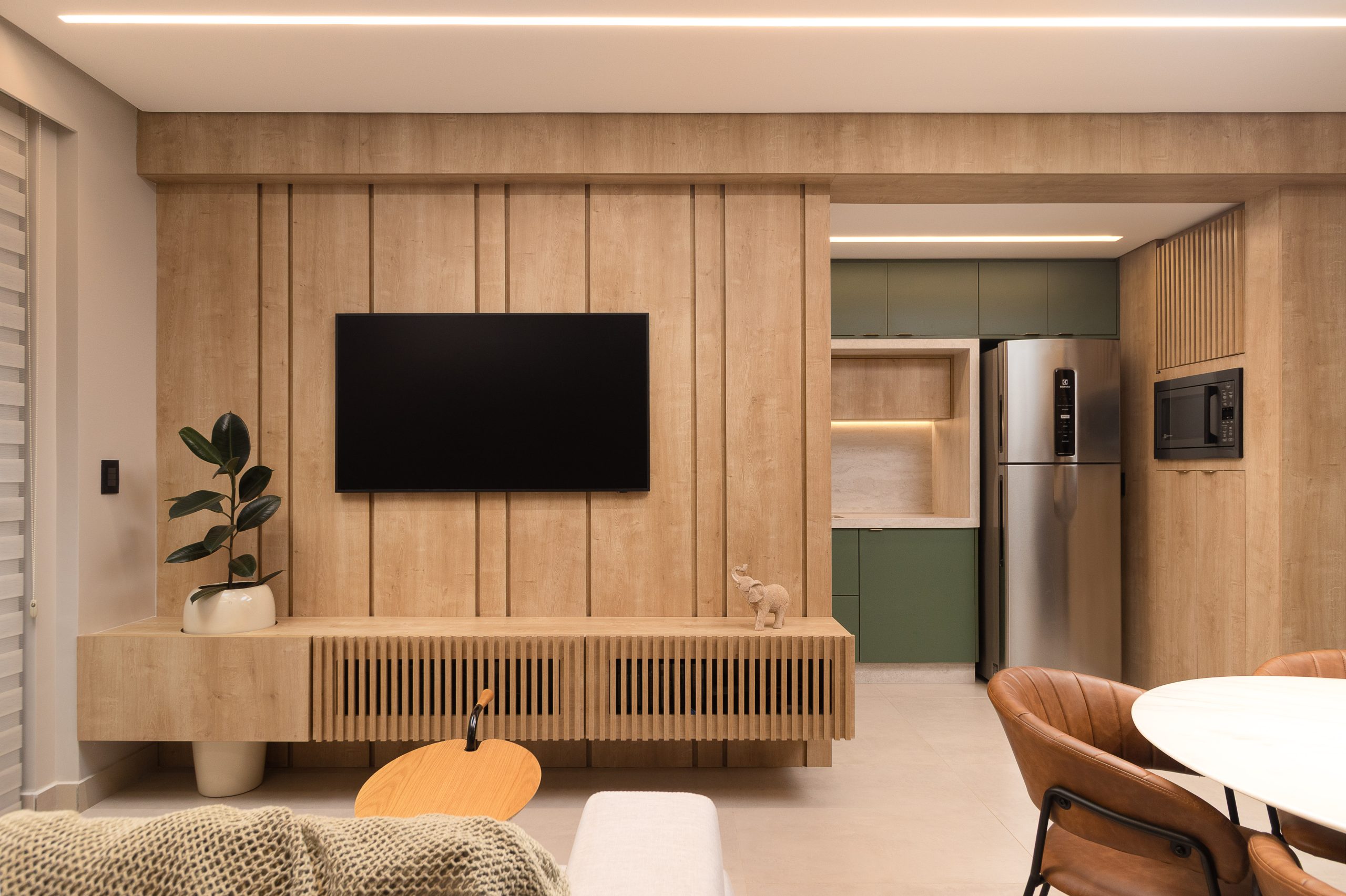 apartamento studio compacto de alto padrão, sala, home office, e cozinha integrados com portas mimetizadas padrão BERG