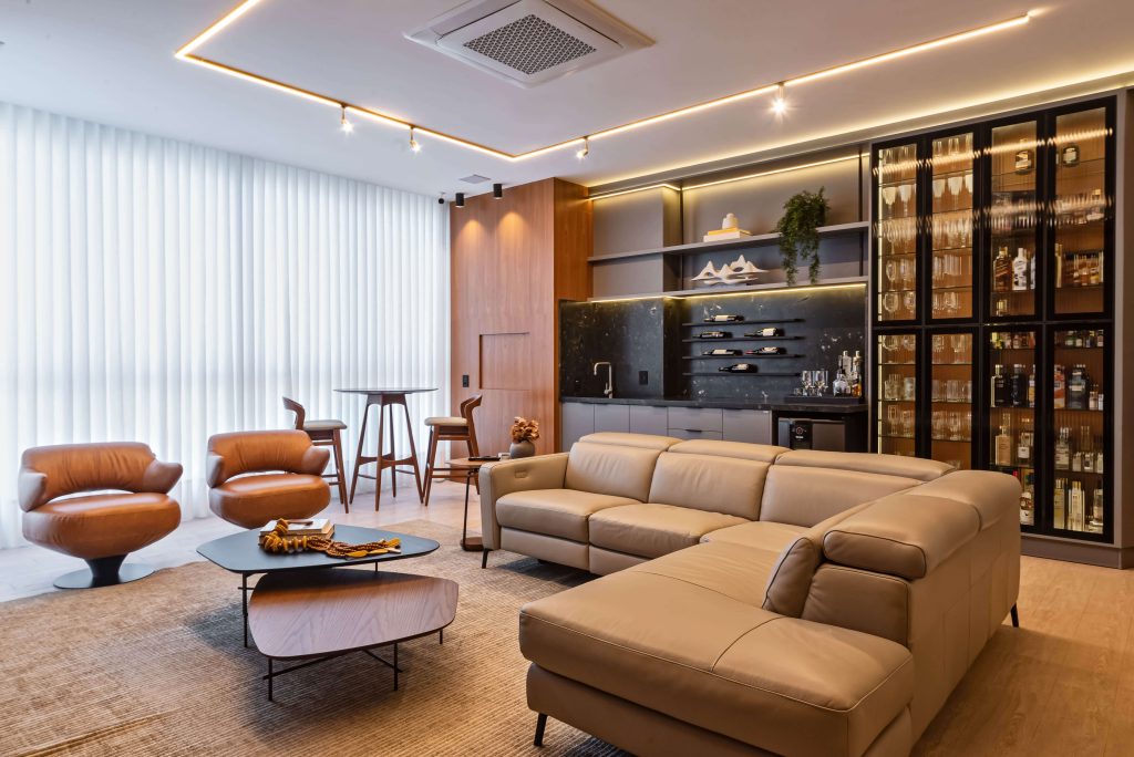 Hobby space - Sala de Vinhos - Sala integrada com painéis planejados Finger e mobiliário sob medida. O uso de madeira FREIJÓ e iluminação quente cria uma atmosfera de conforto, sofisticação e equilíbrio estético. Sala planejada de alto padrão, painéis sob medida, design de interiores Finger. Móveis orgânicos e linhas fluídas. Ambiente integrado com cozinha, churrasqueira, adega e bar.