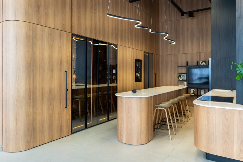 Cozinha Edles com ilha curva e arredondada, com adega e suporte de vinhos da Villaggio. Tendência de cozinha 2026