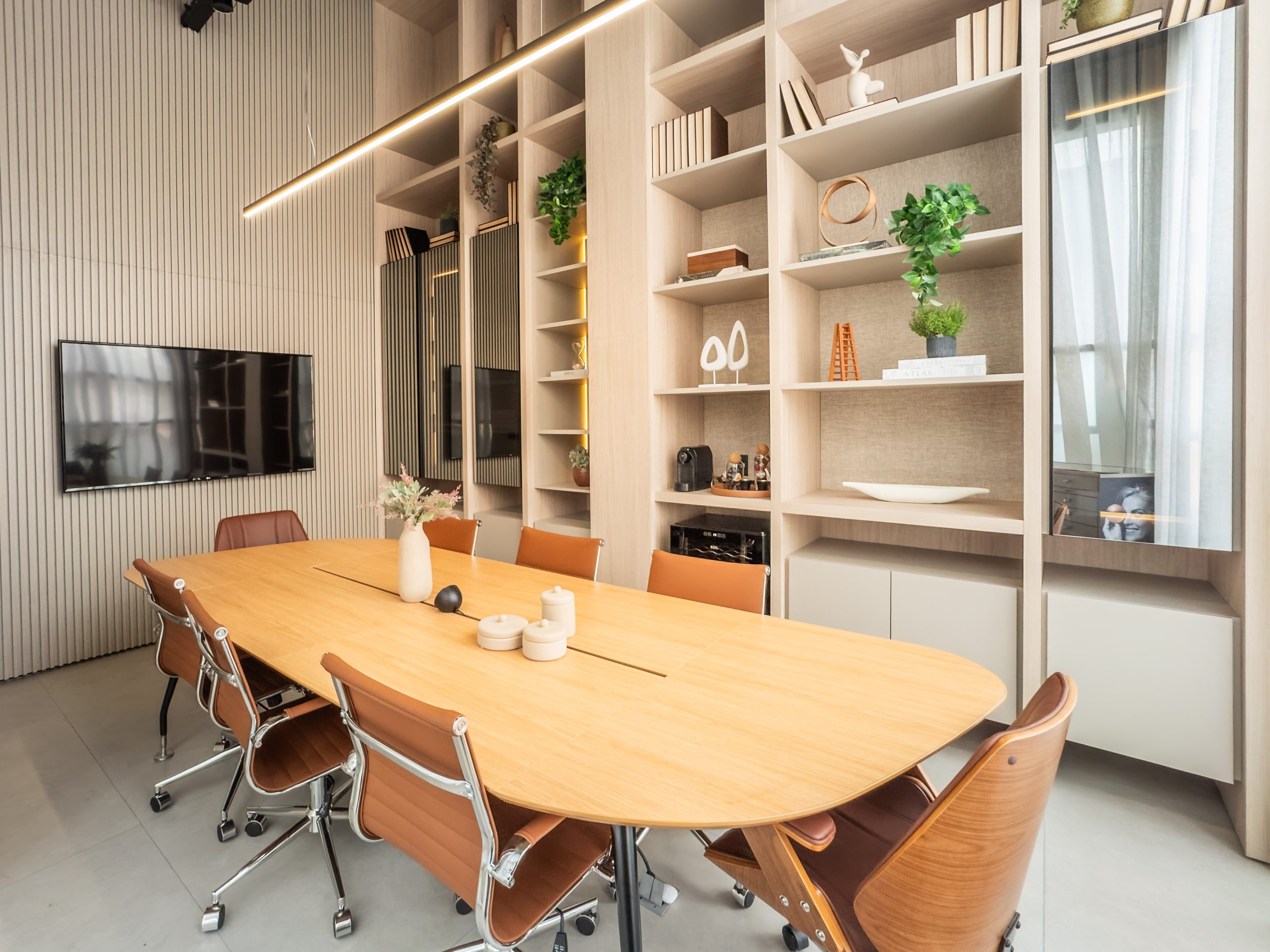 Estante - Sala de Reuniões em tons claros com parede ripada, estante com nichos abertos e portas reflecta fumê