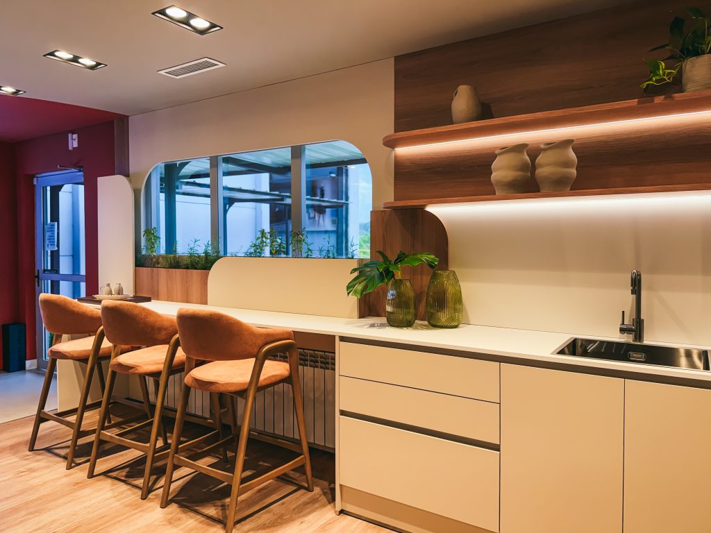 Showroom Zeithaus - Finger Ambientes Personalizados. Cozinha Planejada com Ilha, sistema Furn Spin Giratório. Formas orgânicas, prateleira com iluminação embutida, Handless MDF, Cristaleira, Porta Frame. Padrão Edles e Ivory. Banqueta para cozinha.