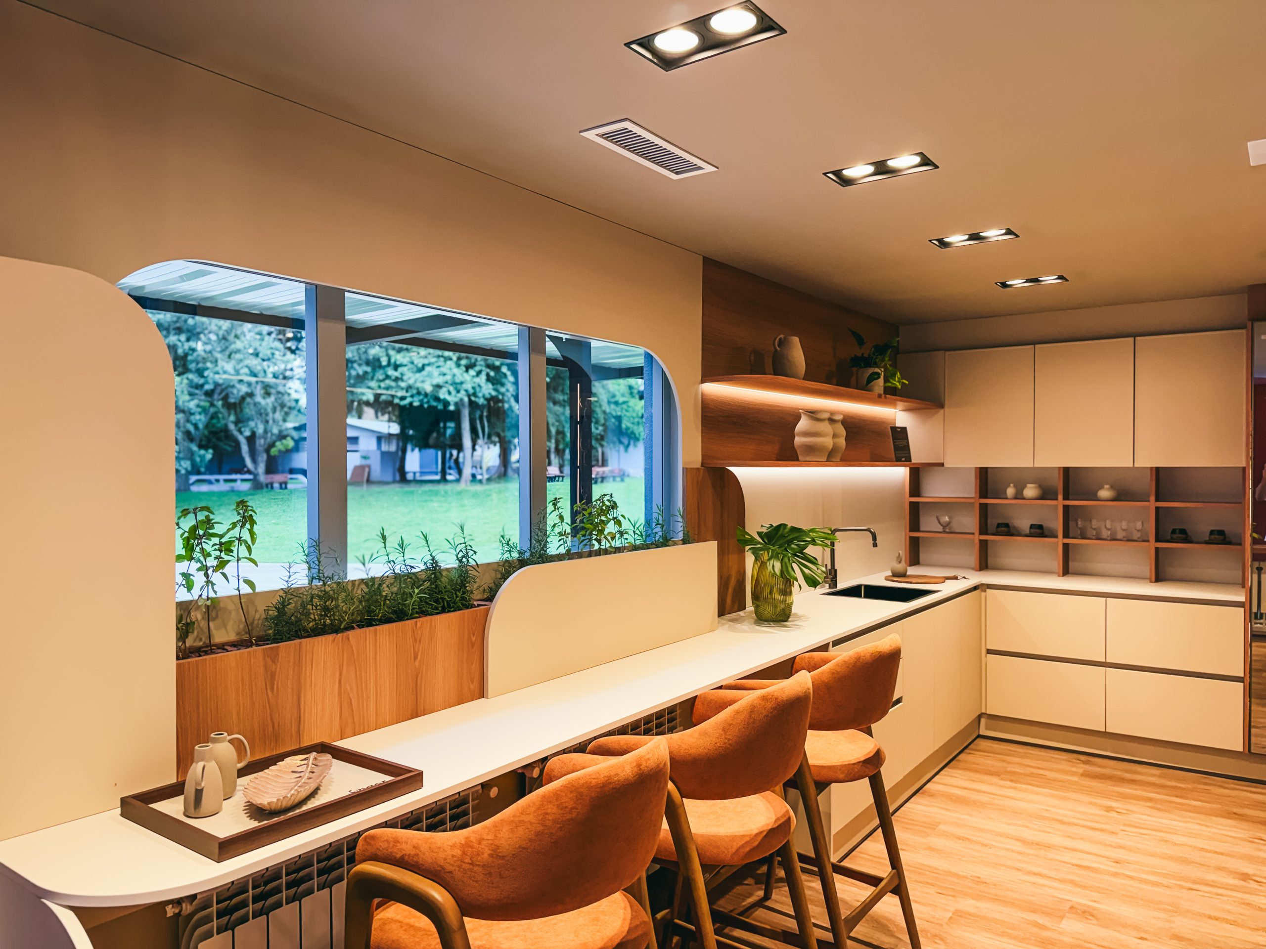 Showroom Zeithaus - Finger Ambientes Personalizados. Cozinha Planejada com Ilha, sistema Furn Spin Giratório. Formas orgânicas, prateleira com iluminação embutida, Handless MDF, Cristaleira, Porta Frame. Padrão Edles e Ivory.