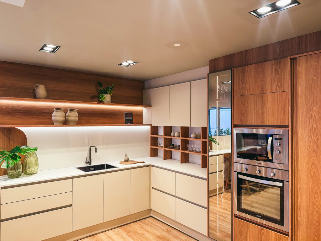Showroom Zeithaus - Finger Ambientes Personalizados. Cozinha Planejada com Ilha, sistema Furn Spin Giratório. Formas orgânicas, prateleira com iluminação embutida, Handless MDF, Cristaleira, Porta Frame. Padrão Edles e Ivory.