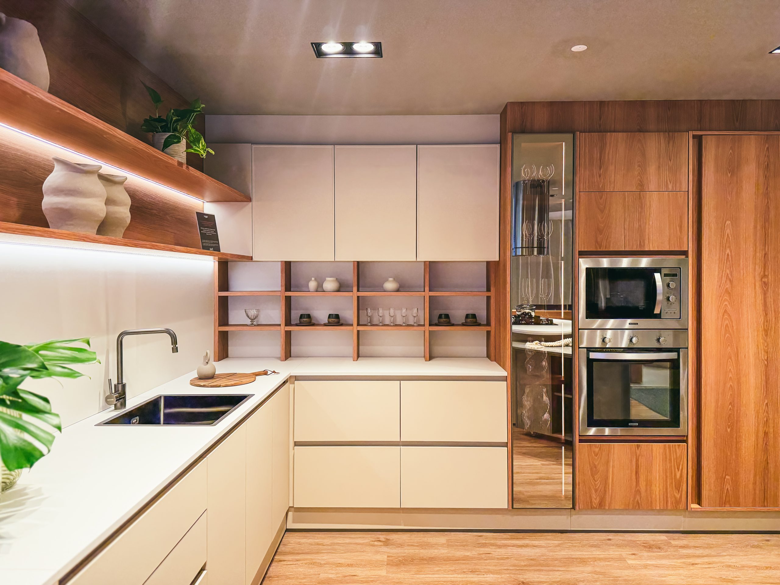 Showroom Zeithaus - Finger Ambientes Personalizados. Cozinha Planejada com Ilha, sistema Furn Spin Giratório. Formas orgânicas, prateleira com iluminação embutida, Handless MDF, Cristaleira, Porta Frame. Padrão Edles e Ivory.