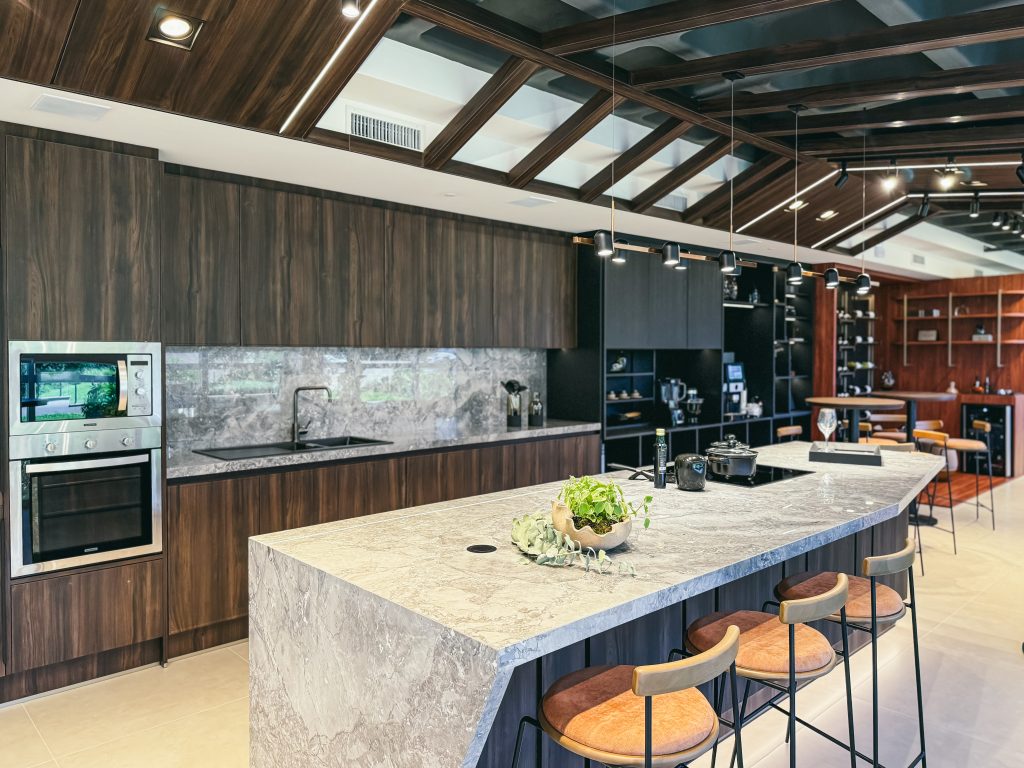 Showroom Zeithaus - Finger Ambientes Personalizados. Cozinha Elegante e sofisticada com padrões escuros com ilha e teto industrial. Sistema Furn Spin giratório. Porta Frame. Padrões Silent e Eben. Iluminação embutida. tipos de puxadores