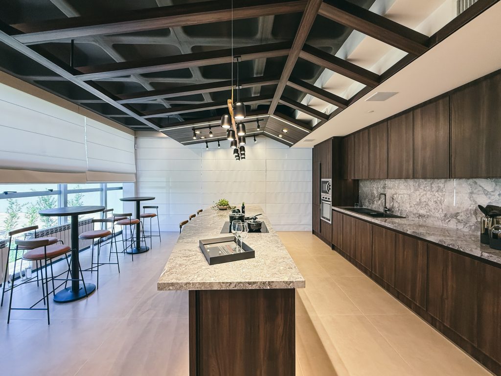 Showroom Zeithaus - Finger Ambientes Personalizados. Cozinha Elegante e sofisticada com padrões escuros com ilha e teto industrial. Sistema Furn Spin giratório. Porta Frame. Padrões Silent e Eben. Iluminação embutida.