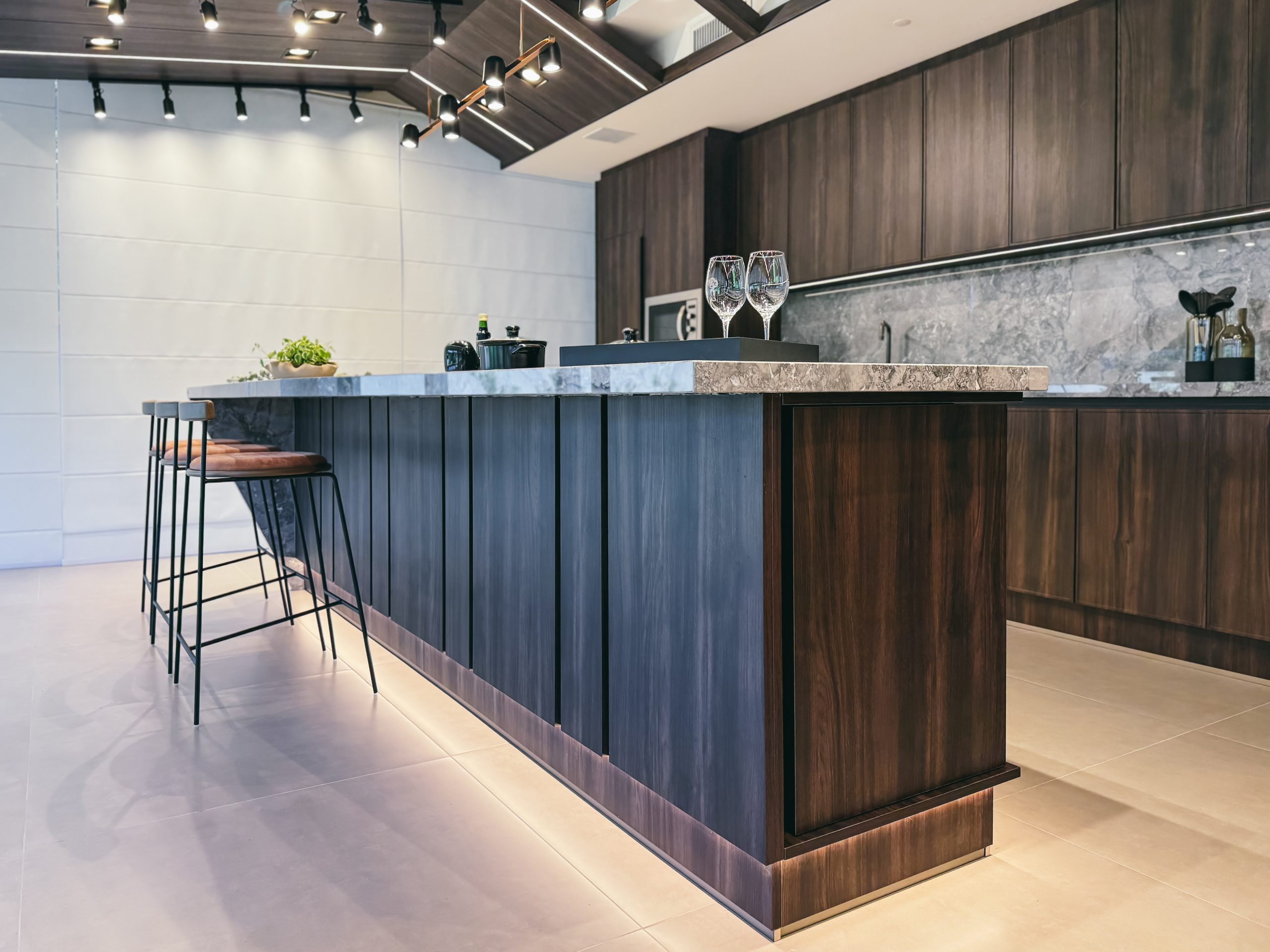 Showroom Zeithaus - Finger Ambientes Personalizados. Cozinha Elegante e sofisticada com padrões escuros com ilha e teto industrial. Sistema Furn Spin giratório. Porta Frame. Padrões Silent e Eben. Iluminação embutida.