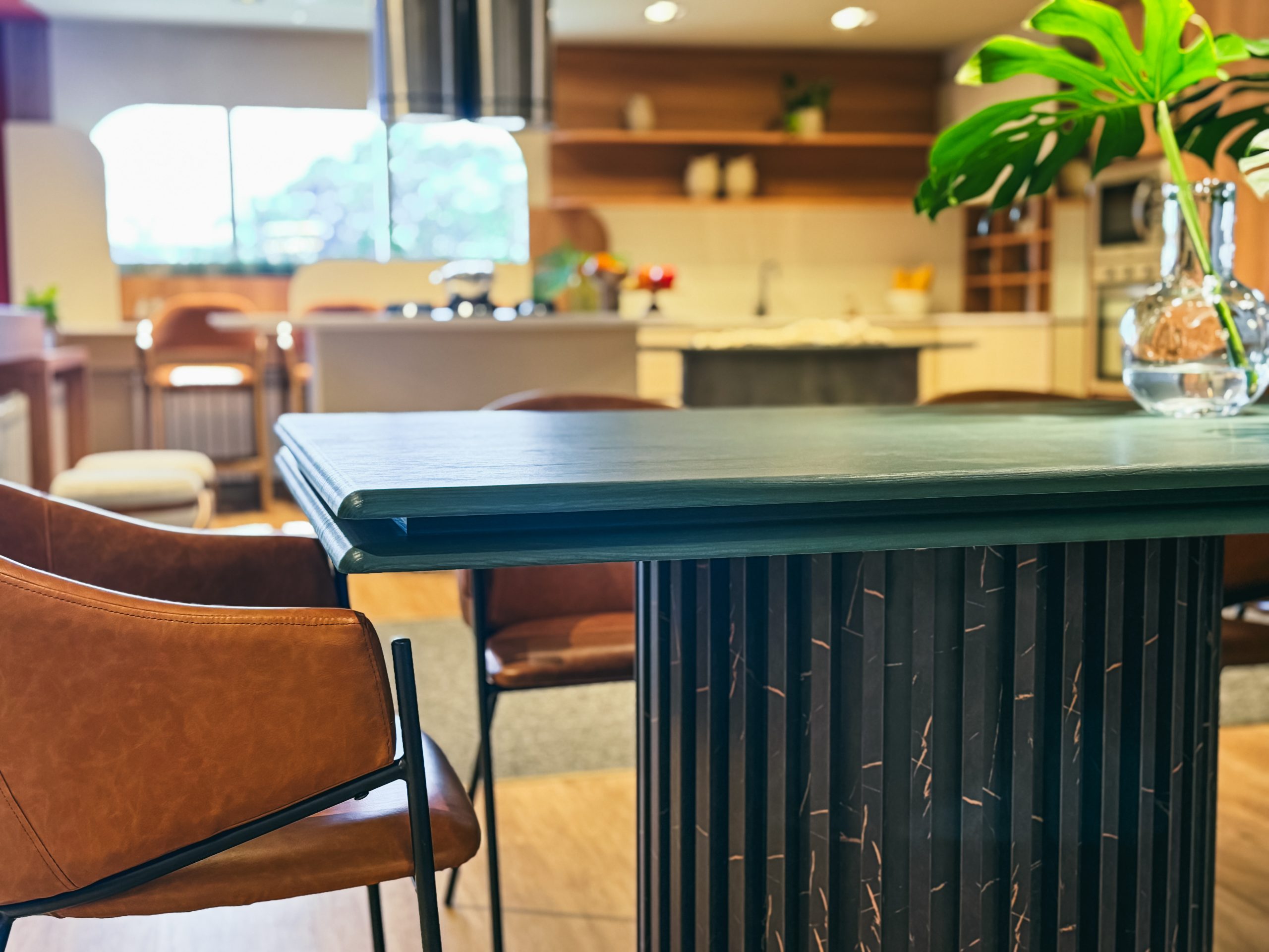 Showroom Zeithaus - Finger Ambientes Personalizados. Cozinha Planejada com Ilha, sistema Furn Spin Giratório. Formas orgânicas, prateleira com iluminação embutida, Handless MDF, Cristaleira, Porta Frame. Padrão Edles e Ivory. Com mesa com borda arredondada.