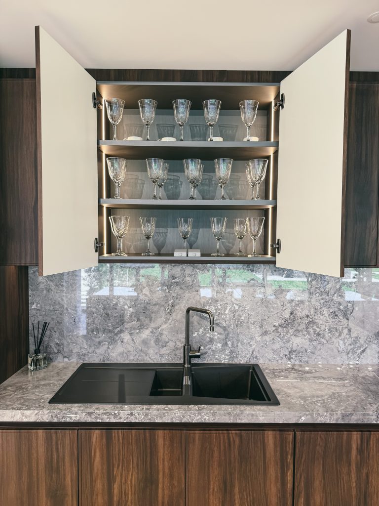 Showroom Zeithaus - Finger Ambientes Personalizados. Cozinha Elegante e sofisticada com padrões escuros com ilha e teto industrial. Sistema Furn Spin giratório. Porta Frame. Padrões Silent e Eben. Iluminação embutida no aéreo internamente.