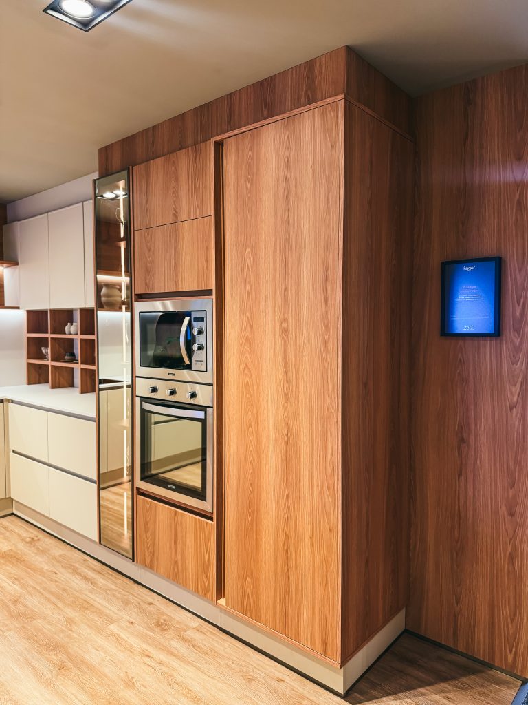 Showroom Zeithaus - Finger Ambientes Personalizados. Cozinha Planejada com Ilha, sistema Furn Spin Giratório. Formas orgânicas, prateleira com iluminação embutida, Handless MDF, Cristaleira, Porta Frame. Padrão Edles e Ivory.