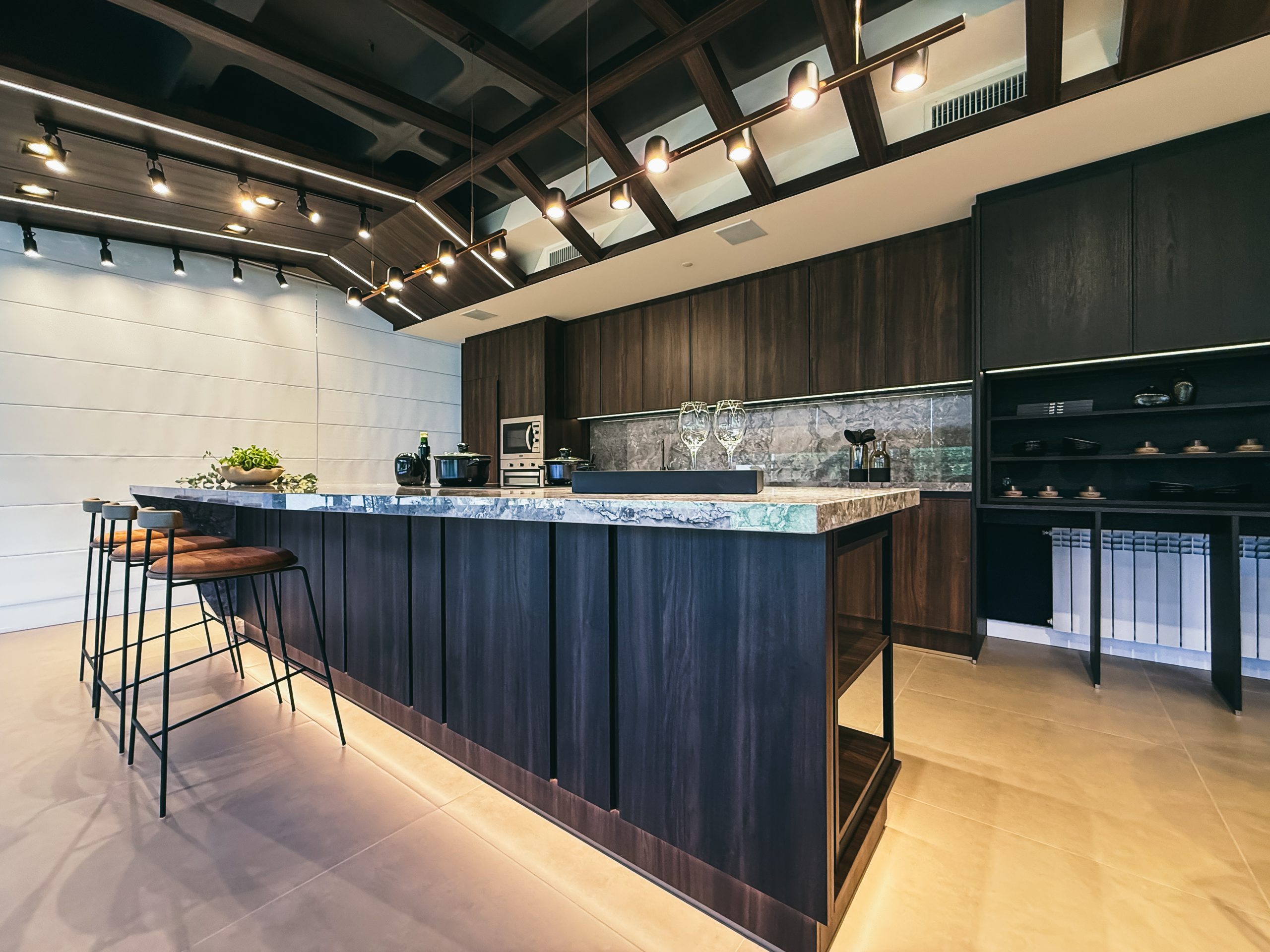 Showroom Zeithaus - Finger Ambientes Personalizados. Cozinha Elegante e sofisticada com padrões escuros com ilha e teto industrial. Sistema Furn Spin giratório. Porta Frame. Padrões Silent e Eben. Iluminação embutida.