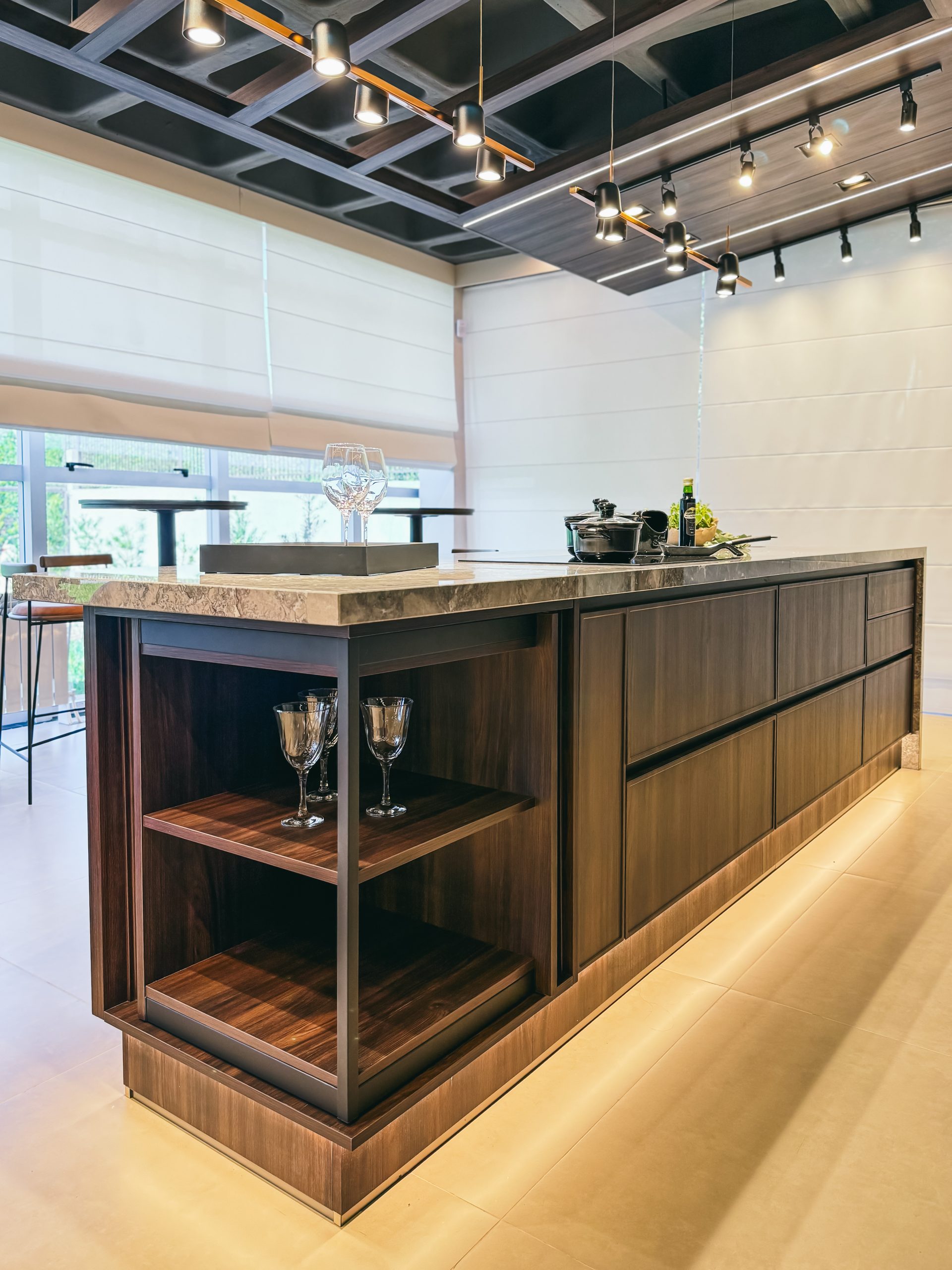 Showroom Zeithaus - Finger Ambientes Personalizados. Cozinha Elegante e sofisticada com padrões escuros com ilha e teto industrial. Sistema Furn Spin giratório. Porta Frame. Padrões Silent e Eben. Iluminação embutida.