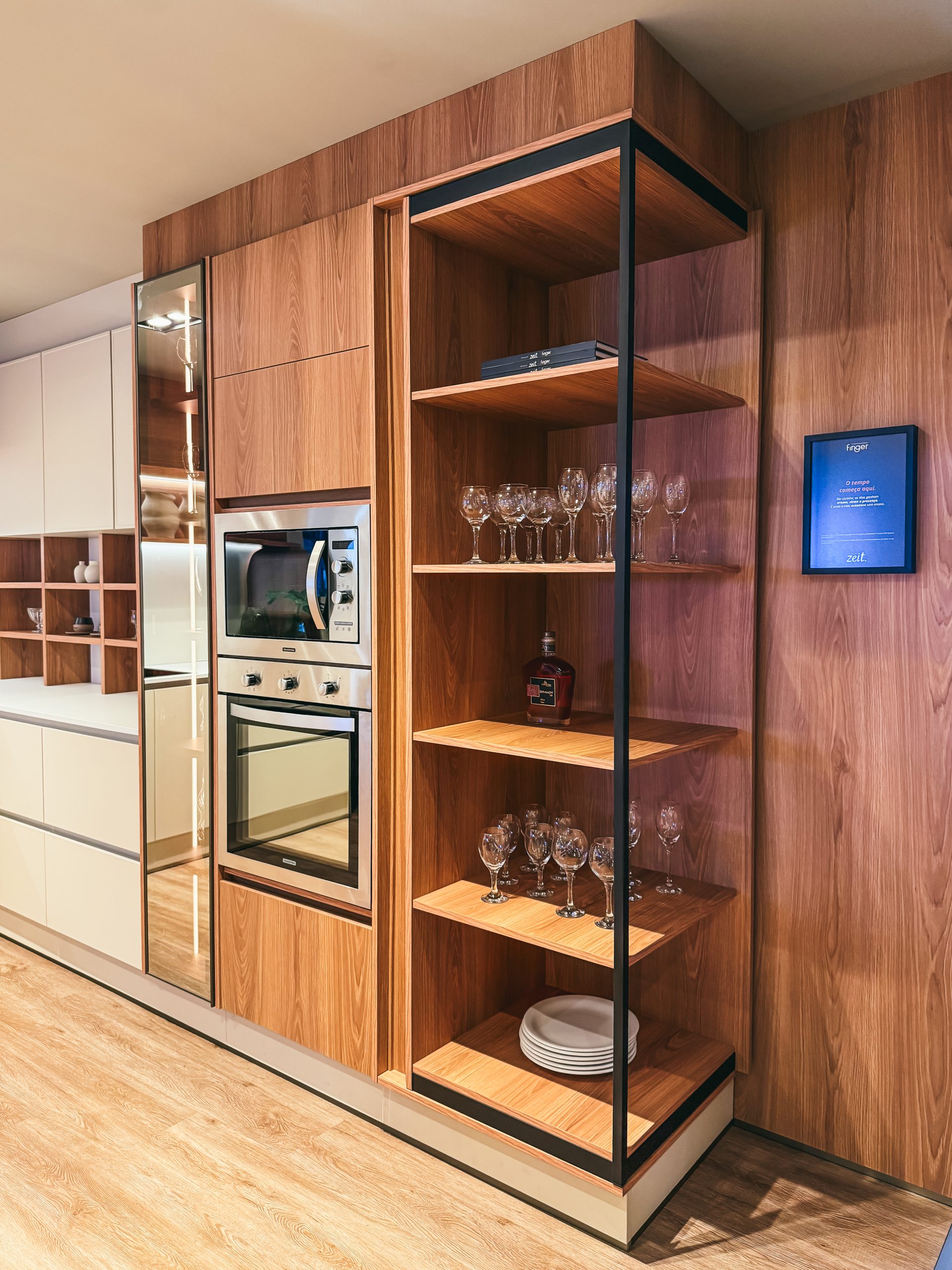 Showroom Zeithaus - Finger Ambientes Personalizados. Cozinha Planejada com Ilha, sistema Furn Spin Giratório. Formas orgânicas, prateleira com iluminação embutida, Handless MDF, Cristaleira, Porta Frame. Padrão Edles e Ivory.