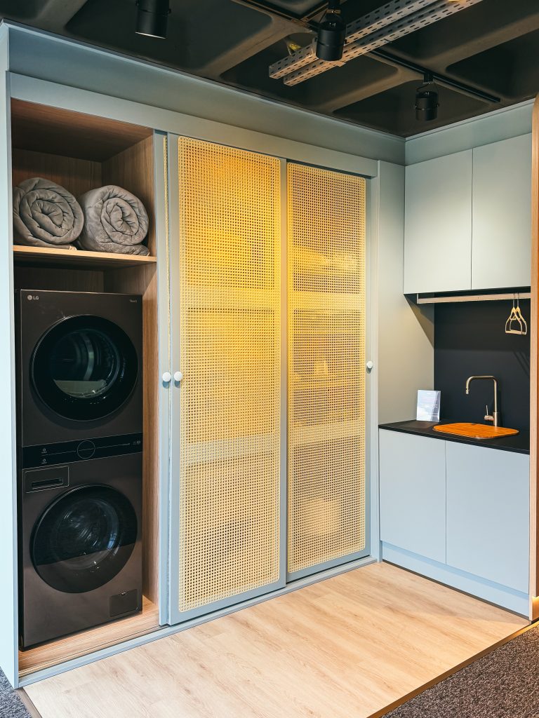 Utility Room - Lavanderia - em tom de azul claro com porta palha, máquina de lava e seca embutida nas portas de correr.