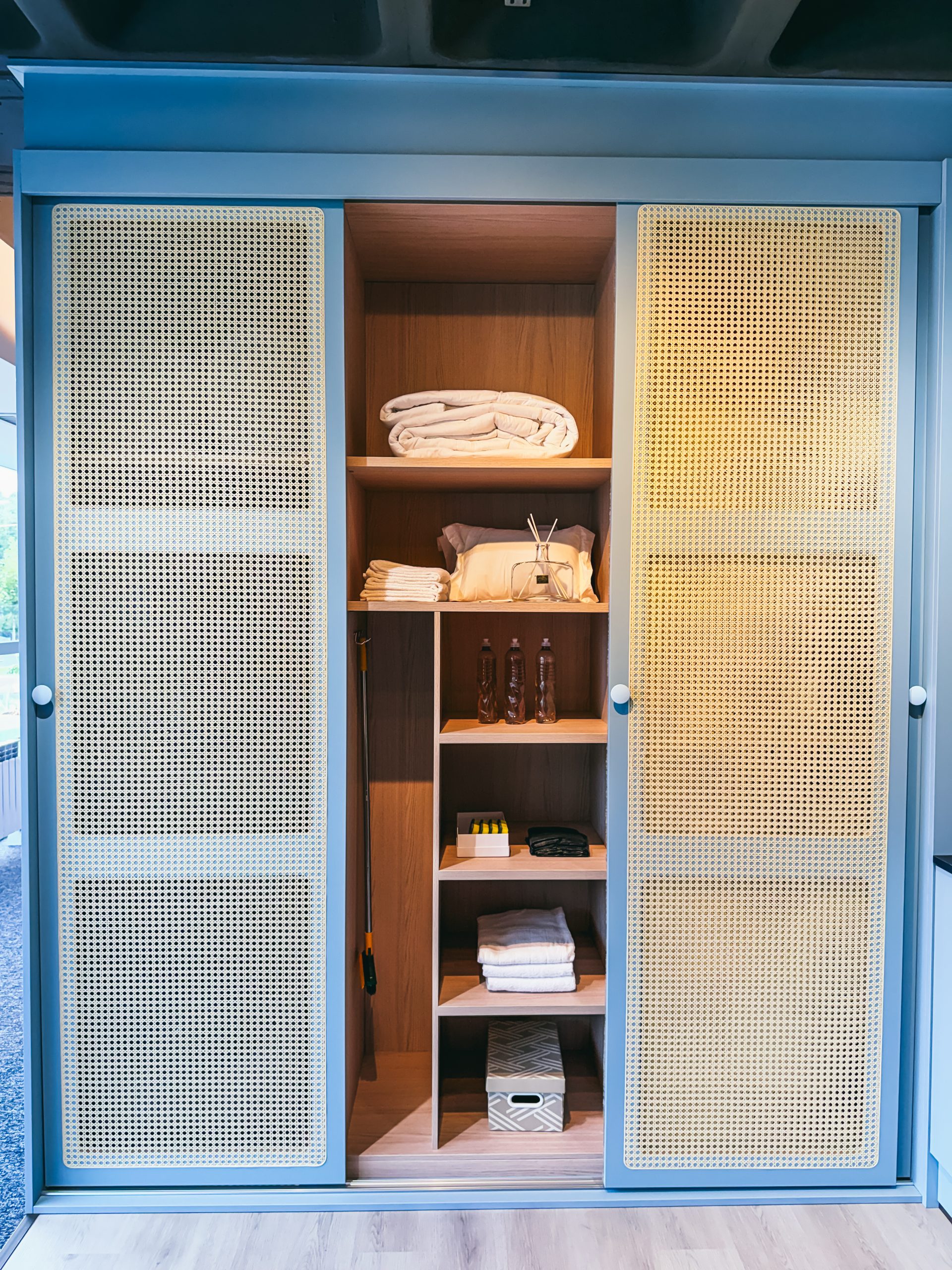 Utility Room - Lavanderia - em tom de azul claro com porta palha, máquina de lava e seca embutida nas portas de correr. 