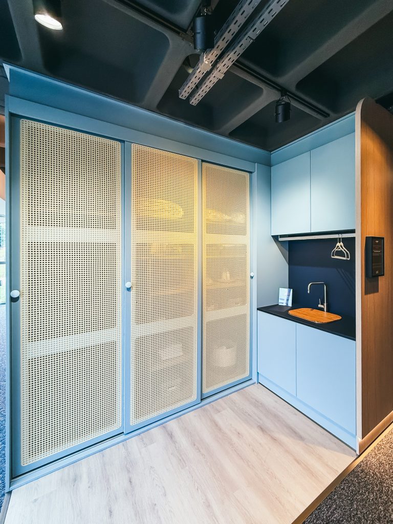 Utility Room - Lavanderia - em tom de azul claro com porta palha, máquina de lava e seca embutida nas portas de correr.