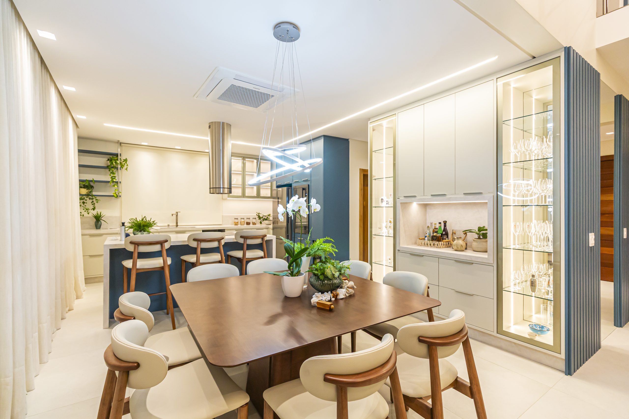 Cozinha Azul e bege com Ilha com cristaleira e sala de jantar