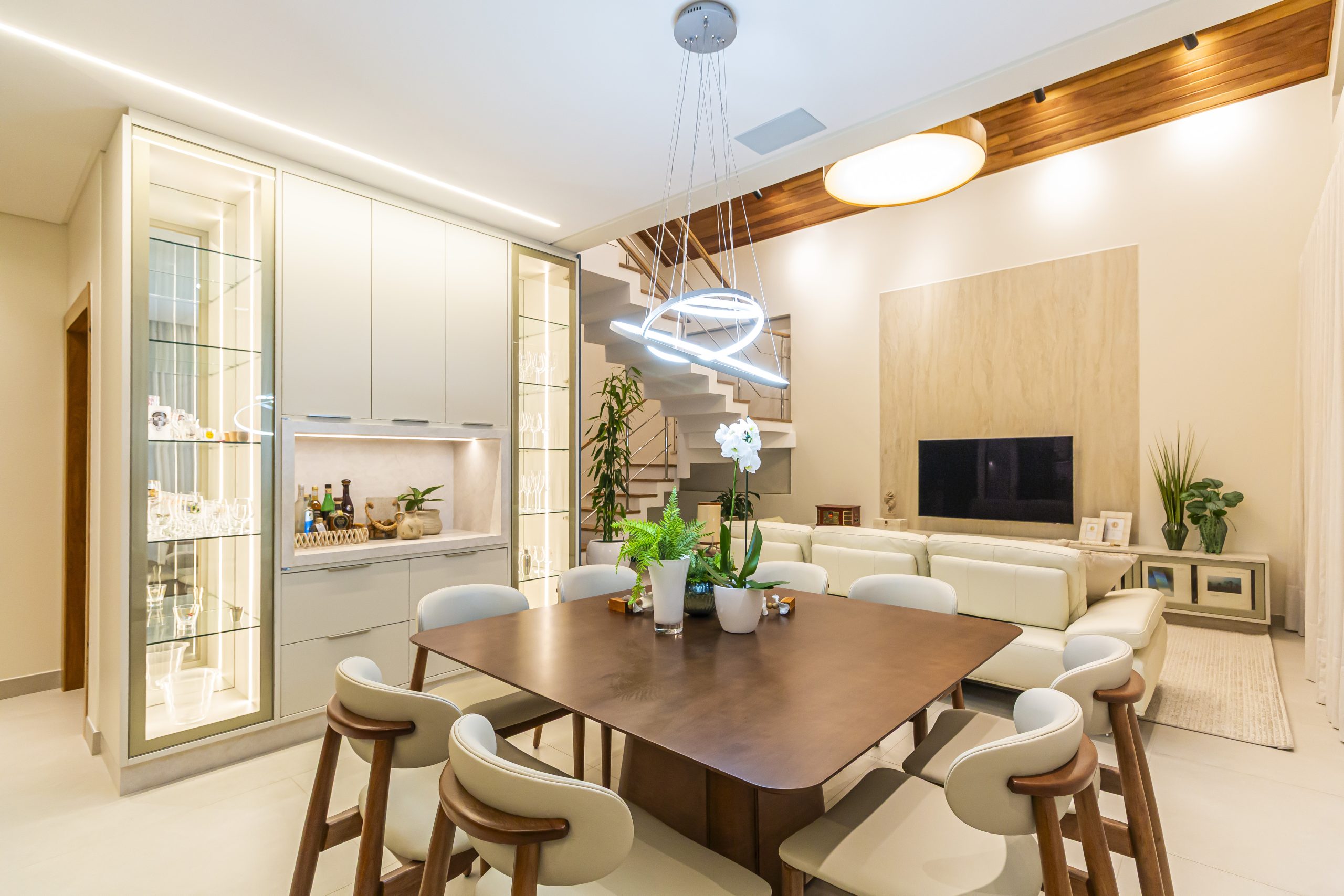 Living integrado com cozinha, em tons claros e azul, sala de jantar e cristaleira