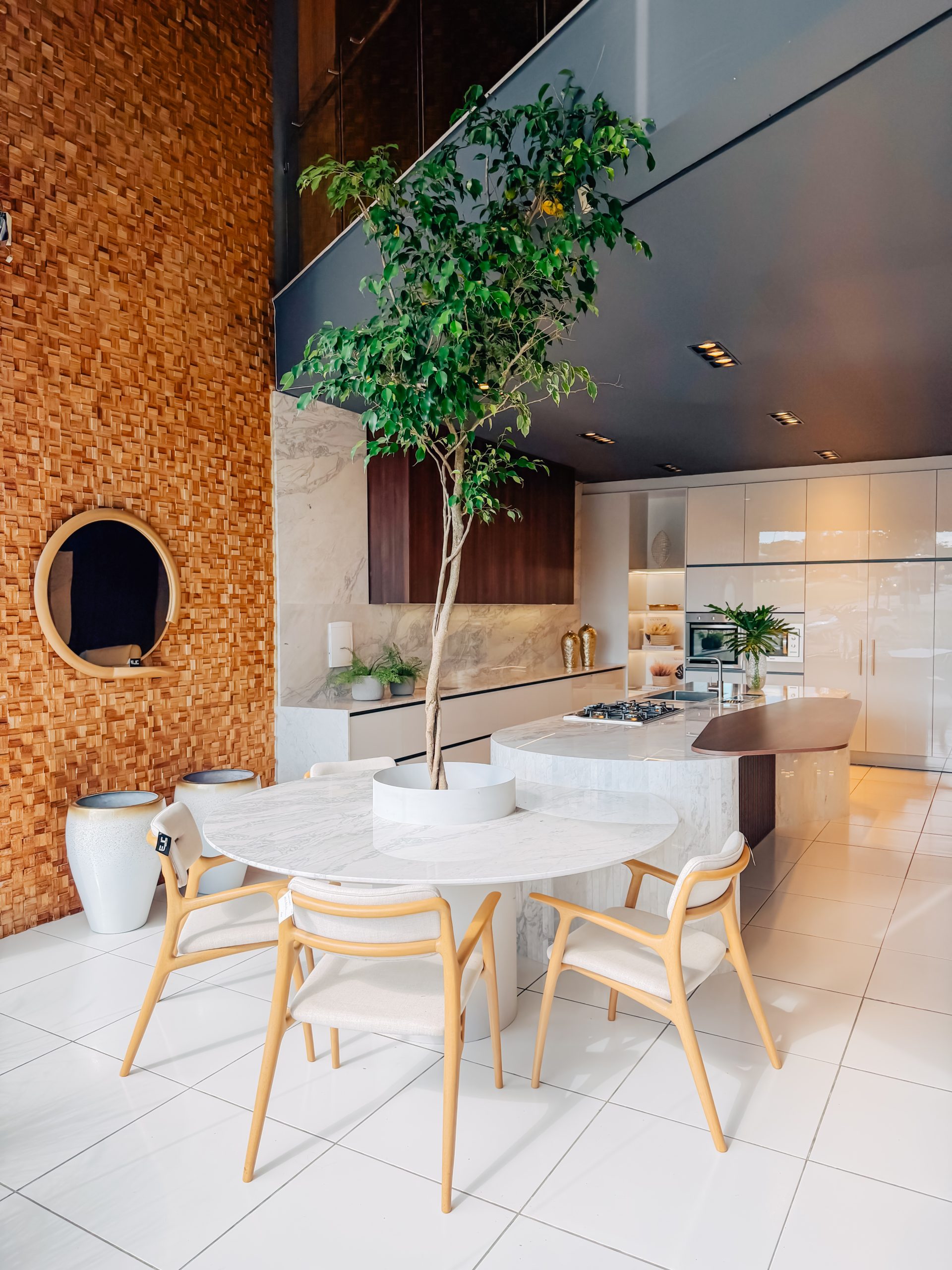 Design de interiores curvas e formas organicas dominam. Linha Kurve. Cozinha planejada com ilha estilo contemporâneo e sofisticado de alto padrão em tons neutros com toque de madeira escura.