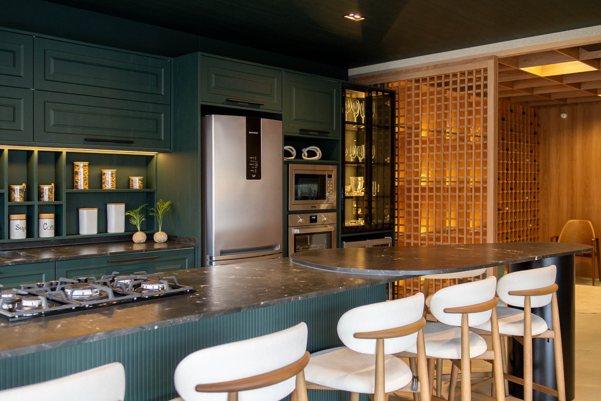 Espaço gourmet sofisticado em tom verde-escuro, com armários planejados clássicos e nichos iluminados. Cozinha Verde provençal Berlin - alto padrão com ilha