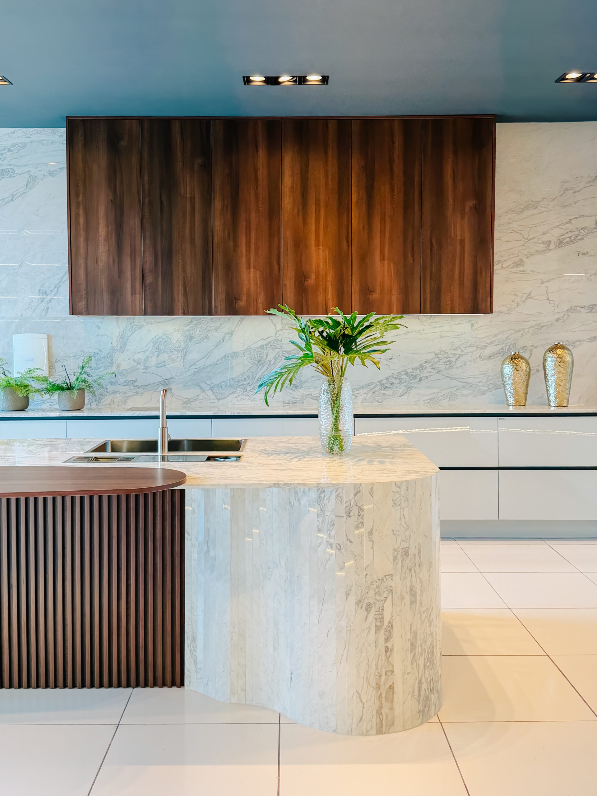 Design de interiores curvas e formas organicas dominam. Linha Kurve. Cozinha planejada com ilha estilo contemporâneo e sofisticado de alto padrão em tons neutros com toque de madeira escura.