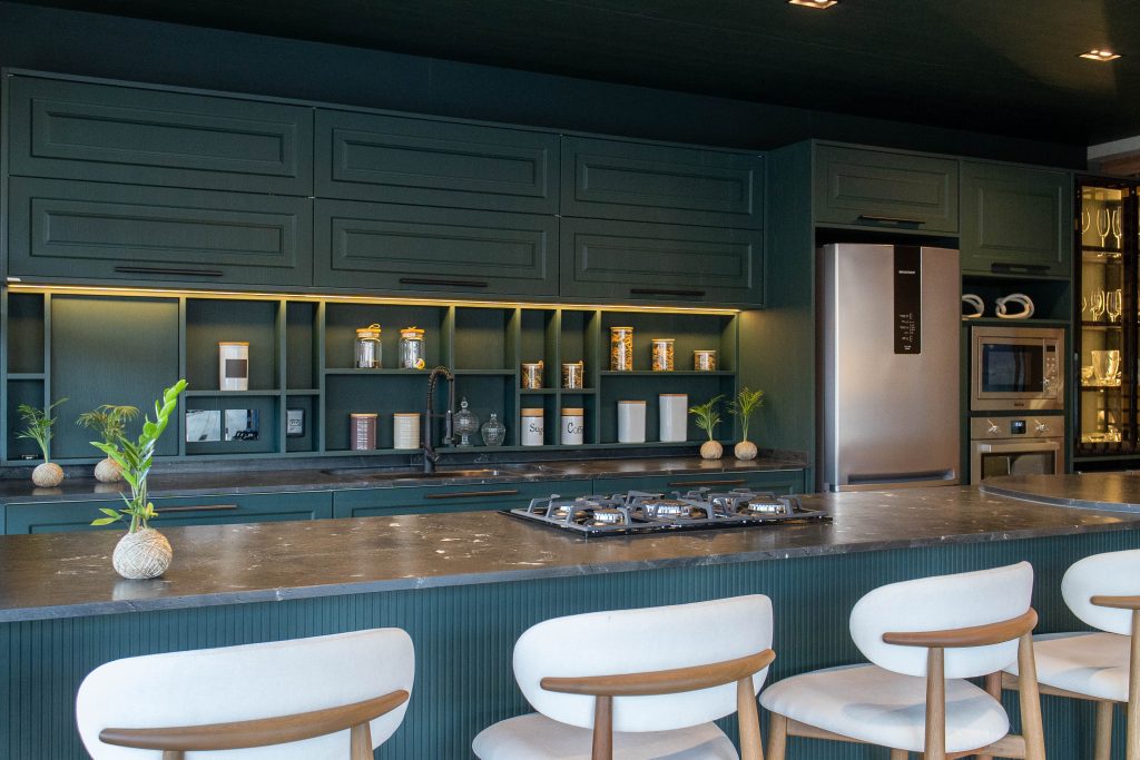 Espaço gourmet sofisticado em tom verde-escuro, com armários planejados clássicos e nichos iluminados. Cozinha Verde provençal Berlin - alto padrão com ilha