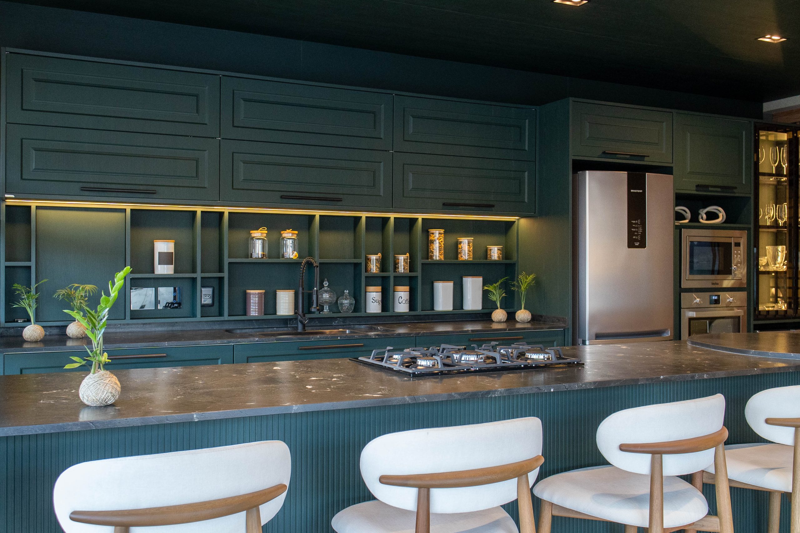 Espaço gourmet sofisticado em tom verde-escuro, com armários planejados clássicos e nichos iluminados. Cozinha Verde provençal Berlin - alto padrão com ilha