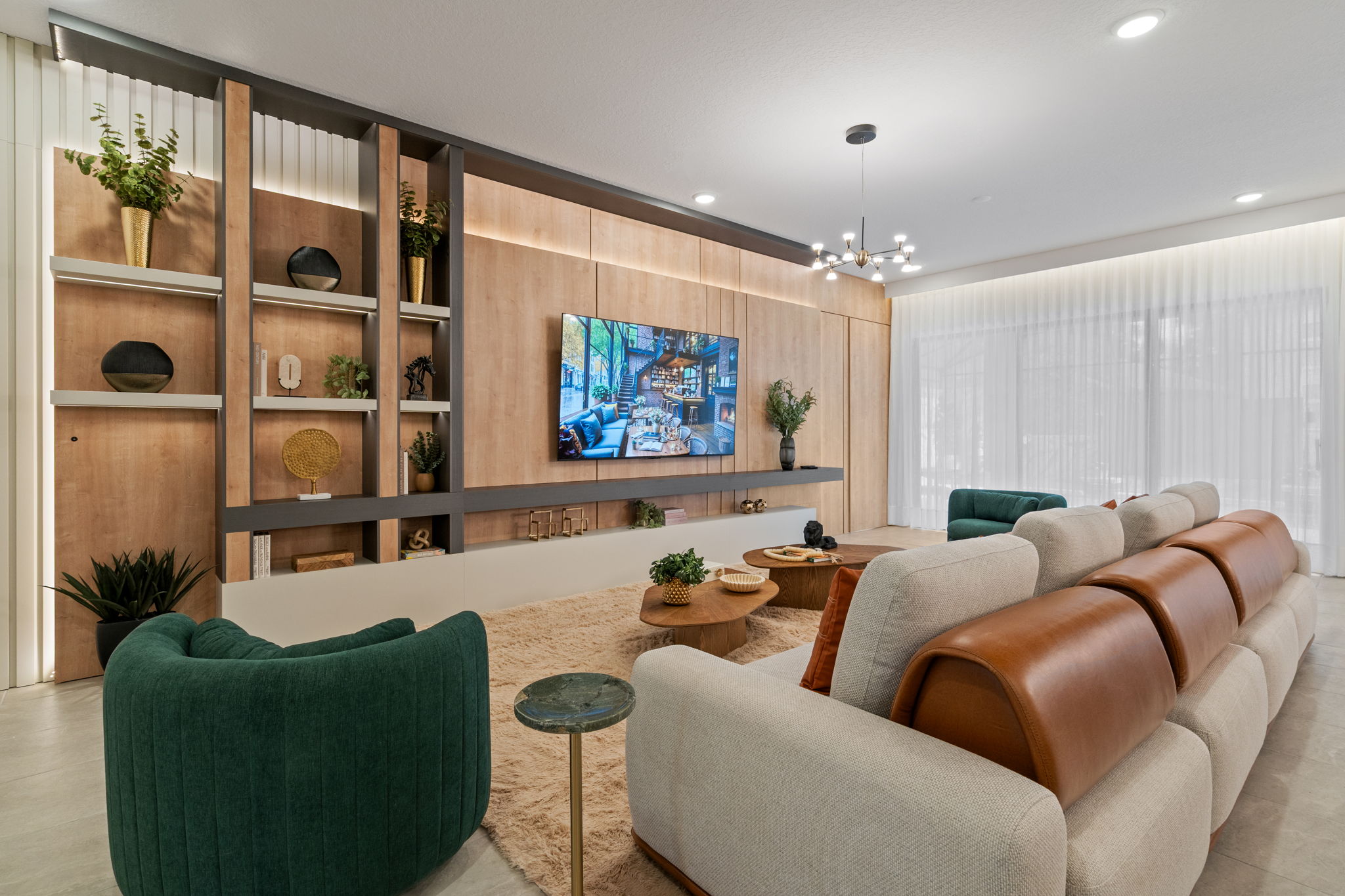 Móveis planejados para Sala de estar ampla e elegante, destacada por um rack planejado estilo bancada baixa integrada com nicho longo aberto, conectado a um grande painel de madeira com molduras escuras e estante lateral decorativa iluminada.